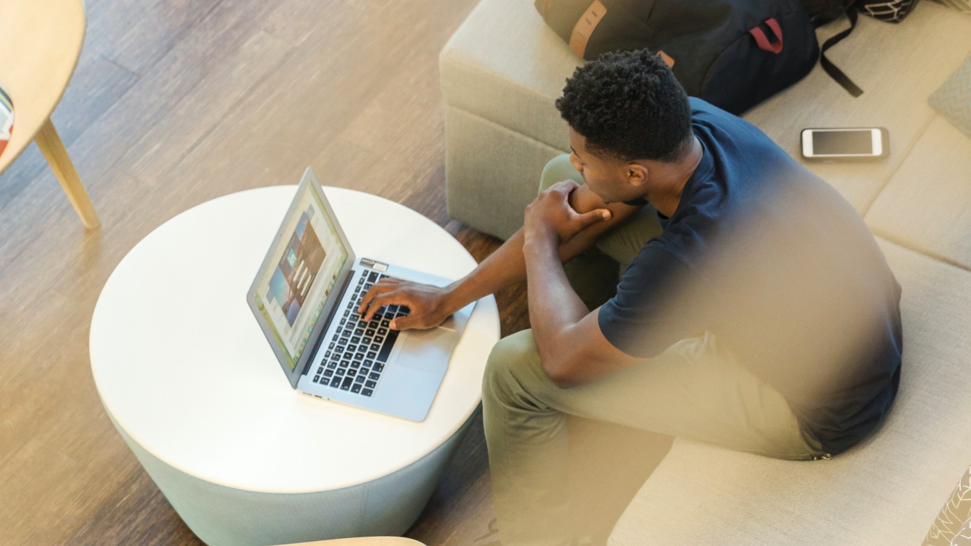 A dark-skinned man working on a laptop